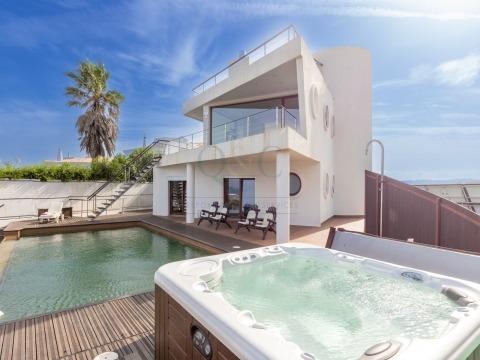 Perched on the clifftop, overlooking the beach, this modern villa was designed by renowned architect João Fonseca. 